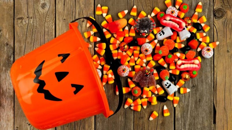 Pile of candy corn in a Halloween bucket, symbolizing unpopular treats