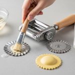 Removing dough from serrated pastry wheel with soft brush